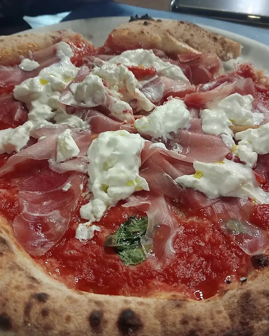 Pizza con prosciutto crudo e burrata appena sfornata nella pizzeria di Cassino