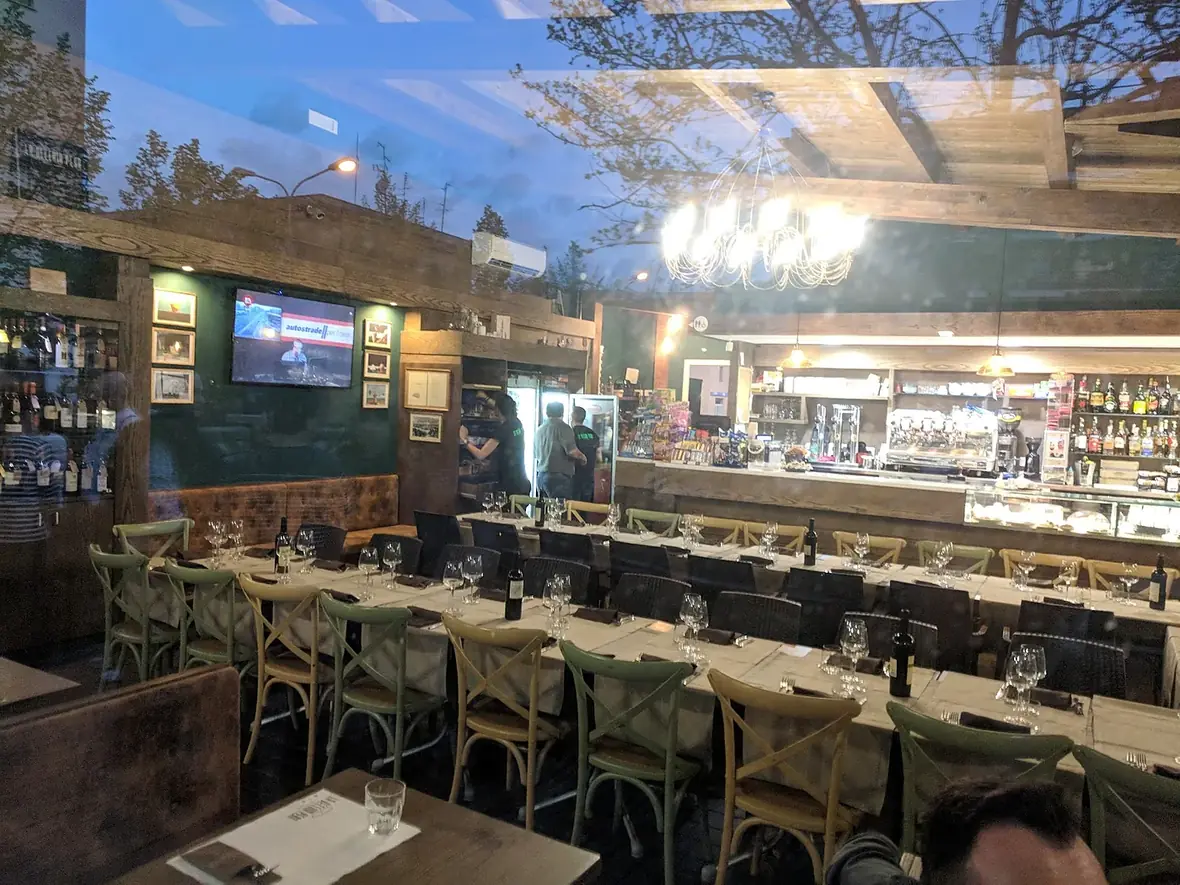La sala allestita con una lunga tavolata apparecchiata davanti al banco del bar